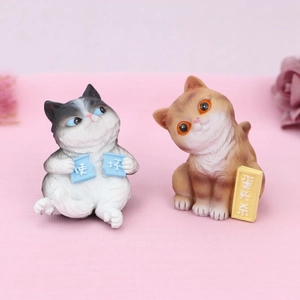 Close-up of cute black and orange cartoon resin cat figurines with decorative signs