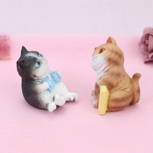 Close-up of adorable resin cat figurines reading books for desk and cake decor