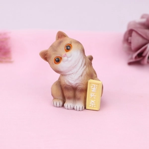 Detail of cute orange resin cat figurine with realistic fur texture and large bright eyes