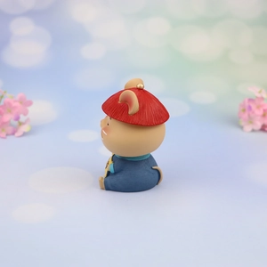 Detail of Chinese style bobblehead mouse car ornament with traditional hat and blue outfit