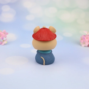 Rear view of a cute mouse car ornament with traditional red hat and blue outfit