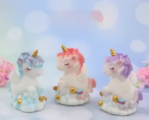Close-up of pastel unicorn figurine with golden wings on cloud base for cake decor