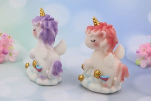 Macro detail of cute pastel unicorn figurines on white clouds with gold star accents