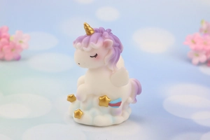 Detailed close-up of a dreamy unicorn figurine with golden horn on a cloud base
