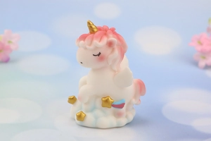 Close-up of cute unicorn figurine on starry cloud base for cake topper or decor