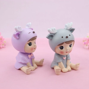 Close-up of cute deer-themed baby figurines in purple and grey colors for cake decor