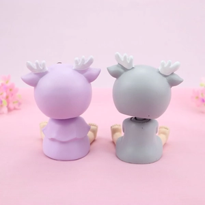 Rear view of cute resin deer cake toppers in purple and grey for birthday decoration