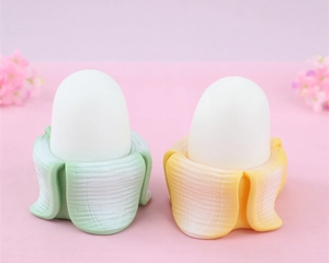 Detail shot of cute banana shaped night light in mint green and pale yellow finish