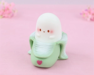 Detail of cute white character inside green banana silicone light on pink background