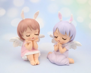 Close-up of cute pink and purple resin angel doll cake toppers with rabbit ears