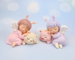 Detailed view of cute resin sleeping angel figures on pink pig and brown bear pillows