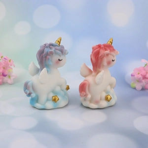 Pair of Nordic unicorn cake toppers with gold horns on cloud bases for nursery decor