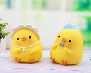Detail shot of cute rubber yellow duck figurines with hats in a garden setting