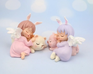 Detail of cute sleeping angel figurines with rabbit ears and wings holding small animals