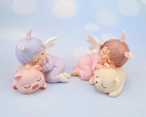 Macro detail of two sleeping angel figurines resting on a pink pig and white bear