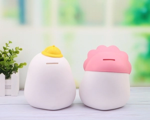 Detail view of duck piggy banks with slot design and cute yellow and pink hat decorations
