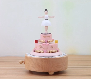 Close-up of wooden cake music box featuring a ballerina and Happy Birthday text engraving