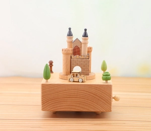 Macro view of handmade wooden music box featuring a castle, car and green trees