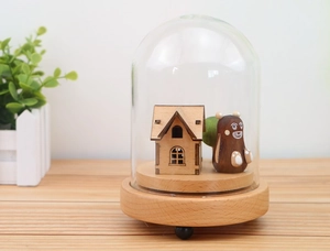 Macro shot of creative wooden music box inside glass dome with forest scene miniatures