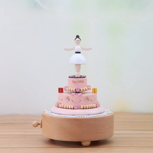 Pink wooden birthday cake music box with spinning ballerina and Happy Birthday carving