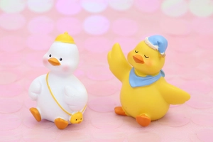 Close-up of cute duck figurines with yellow hats and blue scarves for desk decor