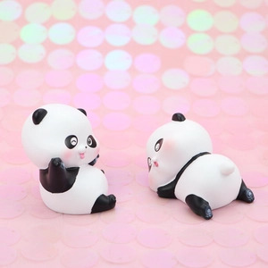Close-up of cute panda figurine with pink cheeks on a sparkling glitter background