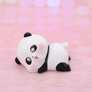 Cute panda cake topper decoration in a crawling pose on a soft pink bokeh background