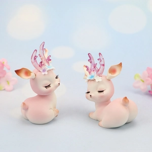 Close-up of pink reindeer cake topper with lavender antlers and floral details
