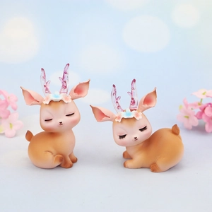 Detail of cartoon reindeer cake toppers with floral crowns and translucent purple antlers
