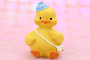 Detail of cute yellow duck car ornament with a blue hat and small crossbody bag decoration