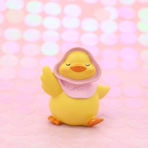 Cute yellow duck figurine with pink hood, cartoon car interior and cake topper ornament