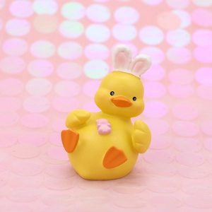 Cute yellow duck car dashboard ornament with bunny ears and pink bear on pink background