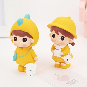 Detail of cute yellow dinosaur and raincoat couple figurines with a small white dog