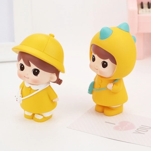 Close-up of cute cartoon doll ornaments wearing yellow dinosaur and sun hat outfits