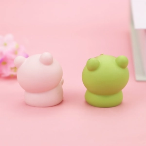 Nahaufnahme von süßem rosa Bären- und grünem Frosch-Squishy-Deko auf rosa Hintergrund