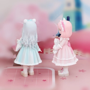 Detail of cute girl figurines in blue and pink Lolita dresses for car or desk decor