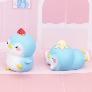 Close-up of cute blue penguin desk ornaments with watermelon and duck accessories