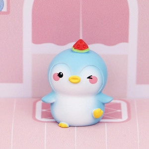 Close-up of cute blue penguin figurine with watermelon hat decoration on office desk