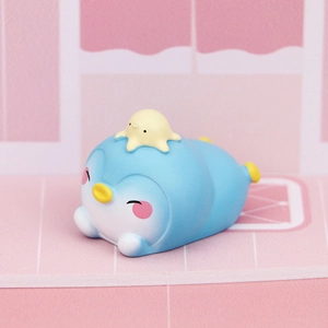 Close-up of cute blue penguin figurine with yellow octopus hat for desk decor