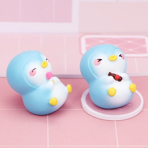 Detailed macro view of cute blue penguin figurines with matte resin texture and candy colors