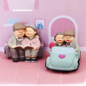 Detailed elderly couple figurines reading together and riding a vintage blue car