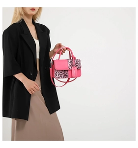 Close-up of pink patent leather and leopard print faux fur details on a crossbody bag