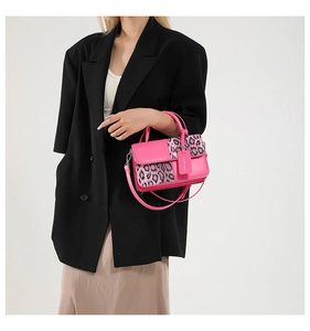 Detail of pink and leopard print handbag with leather handle and branded tag