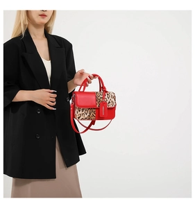 Detail of red leather tote bag featuring leopard print panels and elegant top handle