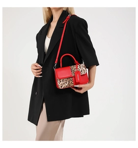 Detail of red leather and leopard print handbag with fashion tag and detachable strap