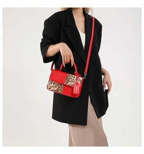 Detail of vintage leopard print crossbody bag with red leather panels and metal hardware