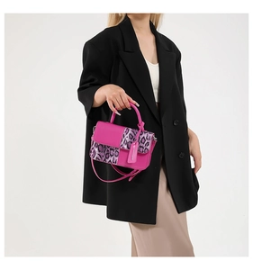 Close-up of rose pink crossbody bag with purple leopard print flap and logo tag