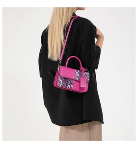 Model wearing hot pink crossbody bag with leopard print accent and black blazer