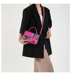Detail of trendy leopard print patchwork crossbody bag with cylindrical top handle and tag