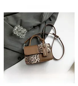 Detailed view of the leopard print texture and premium brown leather finish on the handbag